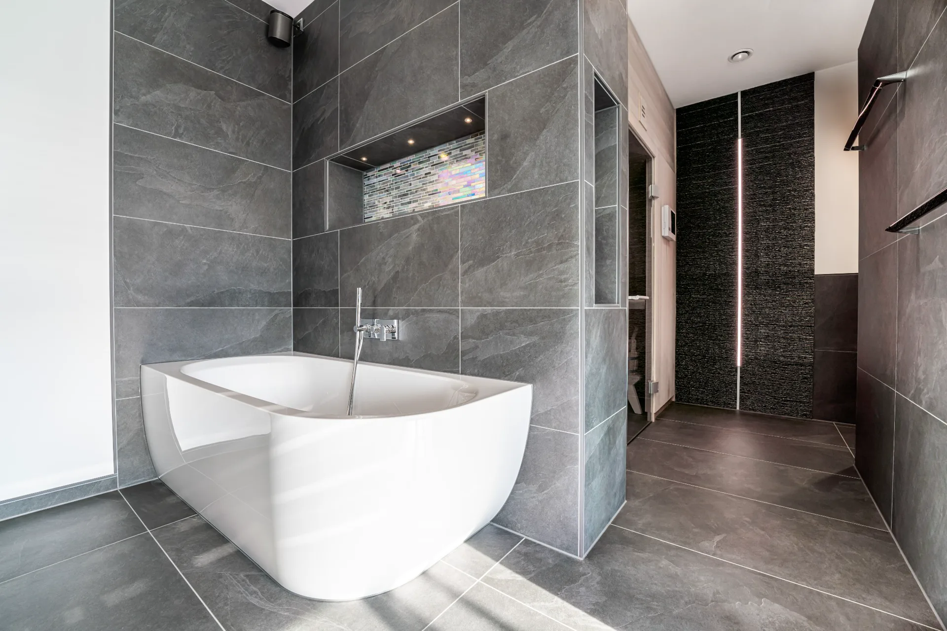 Modernes Bad mit freistehender Wanne und präzise verlegten Großformatfliesen